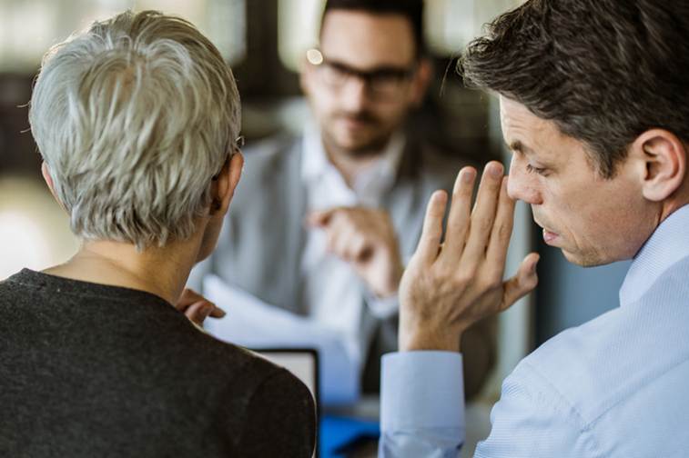 Man whispering to female coworker - Whistleblower Protection